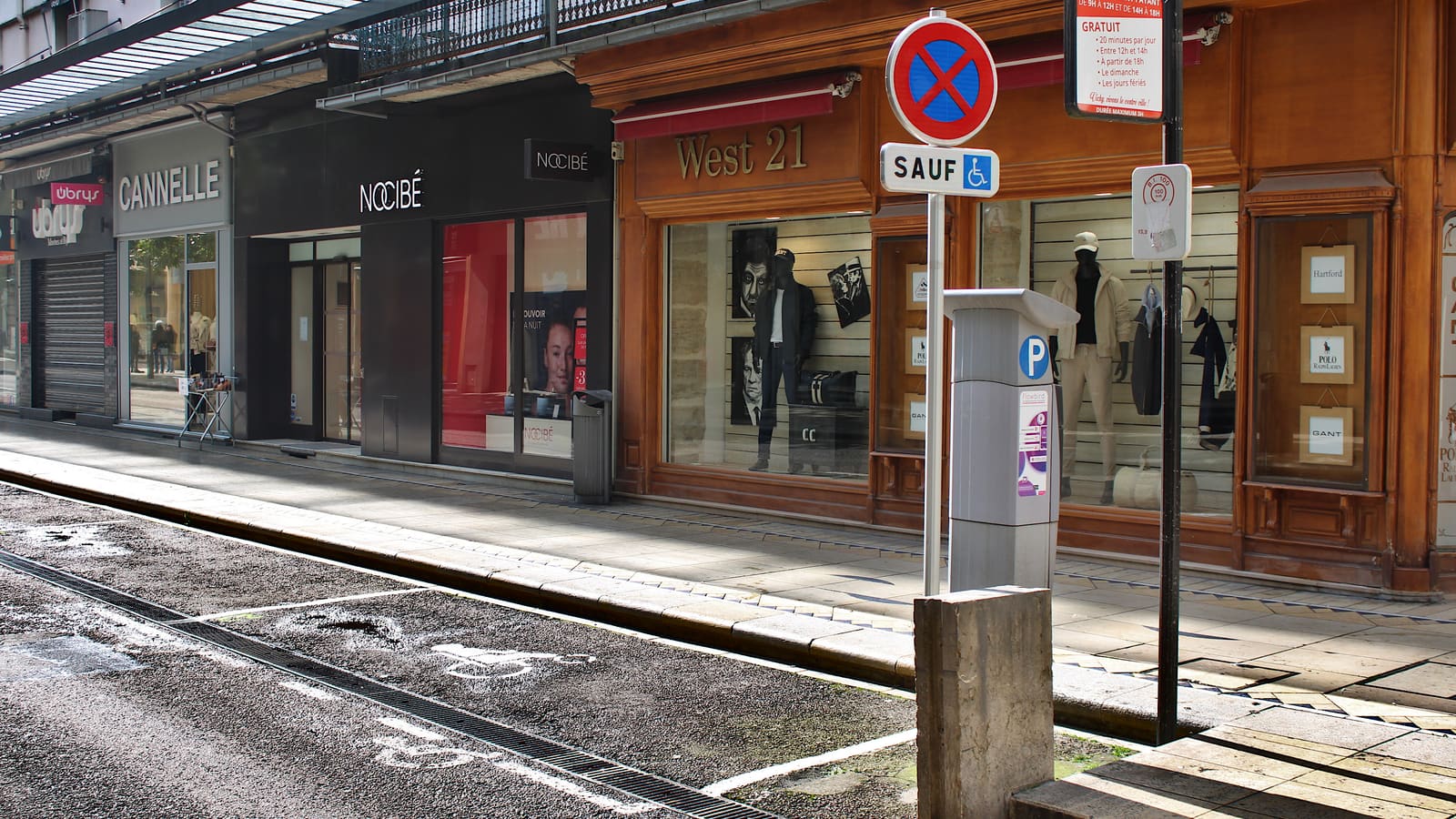 Panneau de place de stationnement réservée aux personnes handicapées, à côté d'un horodateur